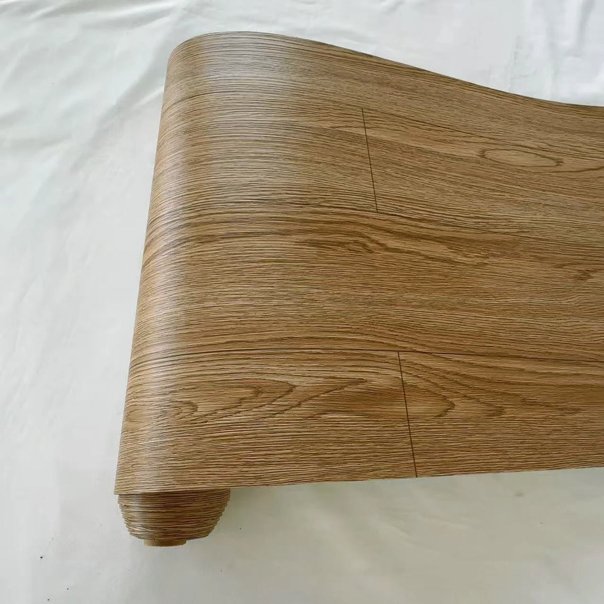 A close-up view of a rectangular wooden panel with visible grain, showing a natural wood texture.