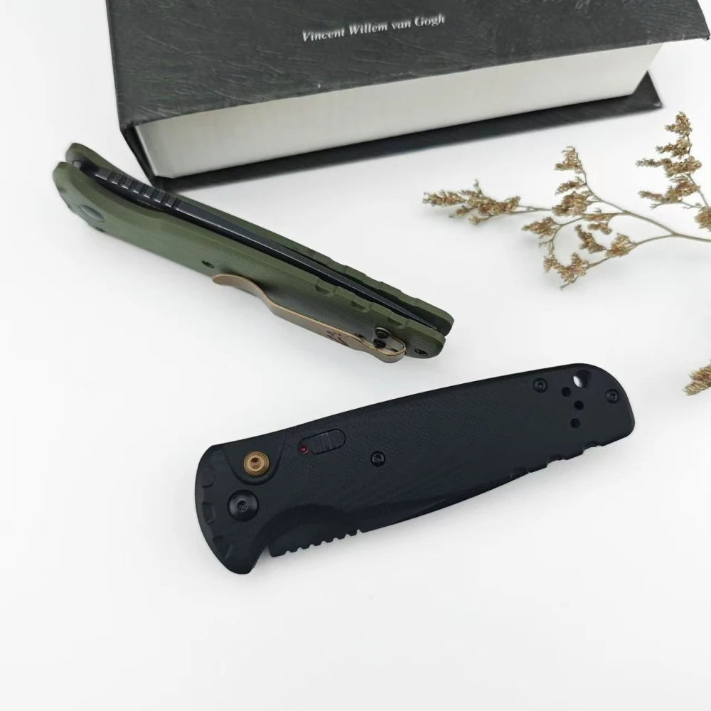 A folding utility knife in olive green is shown next to a black knife and a box.