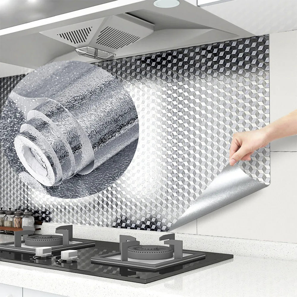 A hand is peeling a sheet of silver aluminum foil from a roll, demonstrating self-adhesive contact sheets for kitchen and hom