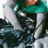 A person wearing gray arm sleeves and gloves is working on a piece of equipment.