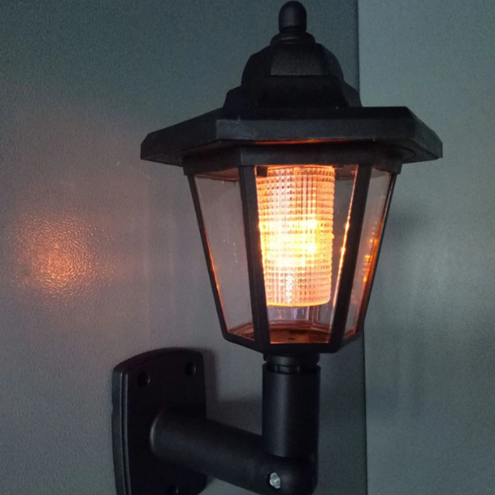 Schwarze solarbetriebene LED-Außen-Garten- und Straßenlaterne, an der Wand montiert.