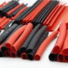 A collection of heat shrink tubing in various shades of red and black, laid out for insulation purposes.