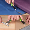 Hands demonstrate the use of folding utility knives with quick change blades on a sheet of blue paper and brown cardboard.