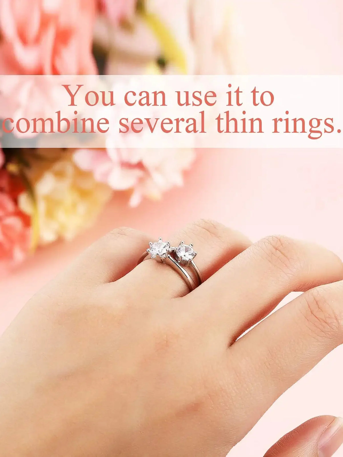A hand wearing a silver ring with two small diamonds, demonstrating the use of adjuster pads for ring sizing.