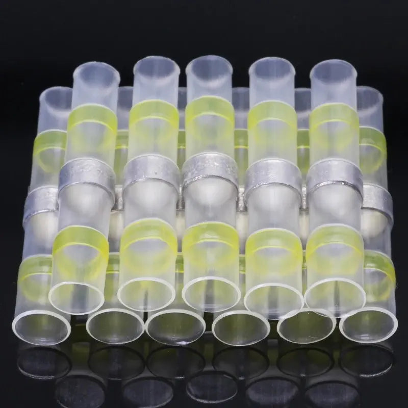 Una fila de conectores de alambre retráctil para calor transparentes en una bandeja de plástico.