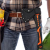 A black nylon axe blade cover is attached to a leather belt worn by a person, with tools visible nearby.