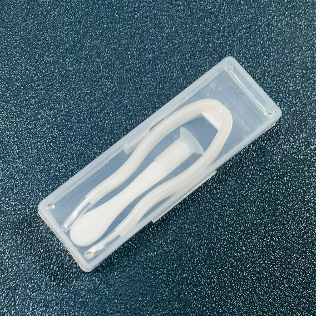 A clear plastic case containing a white portable contact lens tool kit.