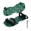 Ein Paar grüne, verstellbare Rasen-Aerator-Schuhe mit Metallspikes und schwarzen Riemen.