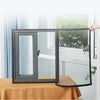 Una persona sostiene abierta una ventana negra con una malla de tela transparente contra un fondo de ventana brillante.