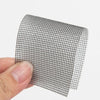 Roll of black heavy duty self-adhesive mesh repair tape being held by a hand