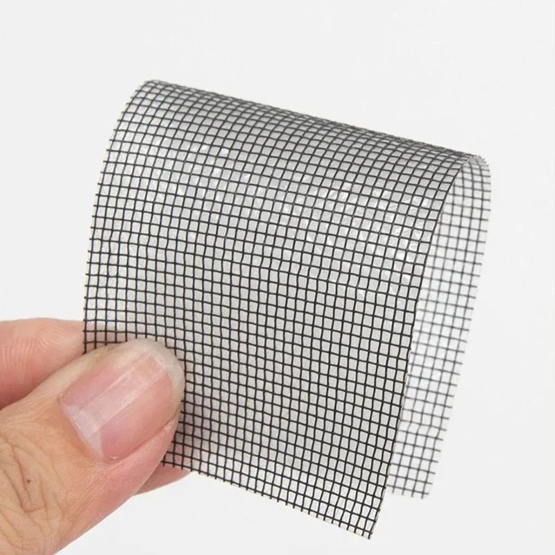 Roll of black heavy duty self-adhesive mesh repair tape being held by a hand