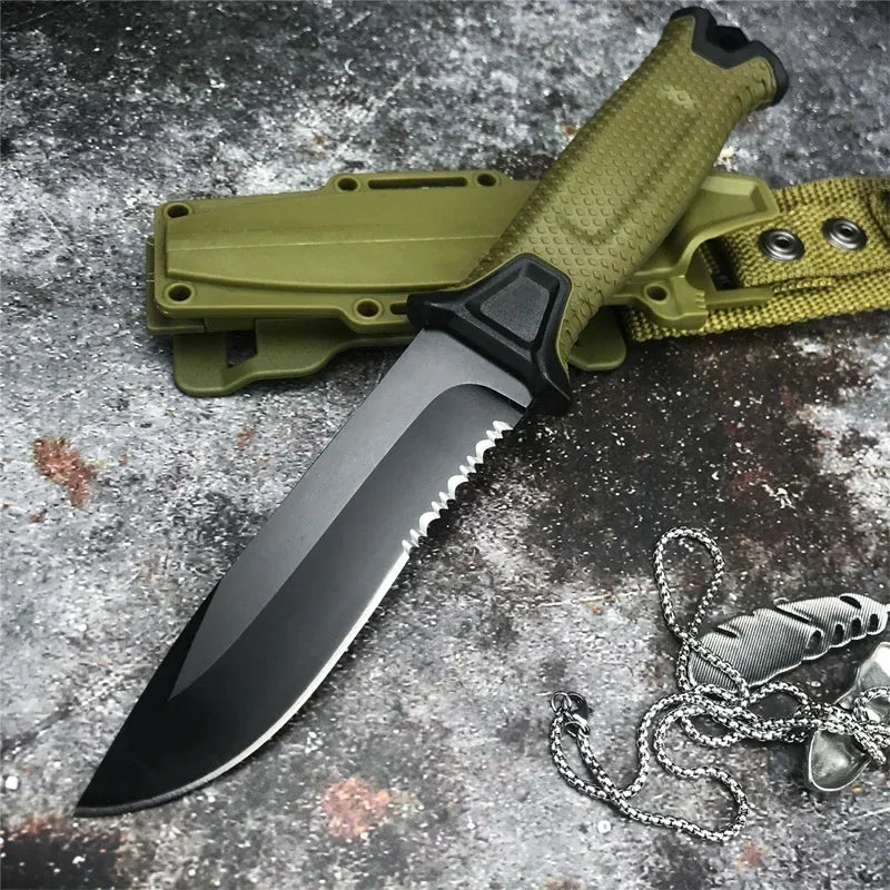 A full tang fixed blade knife with a green sheath and chain resting on a dark, textured surface.