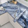 Marble self-adhesive PVC wallpaper featuring blue and gray marble with gold veining on a countertop.