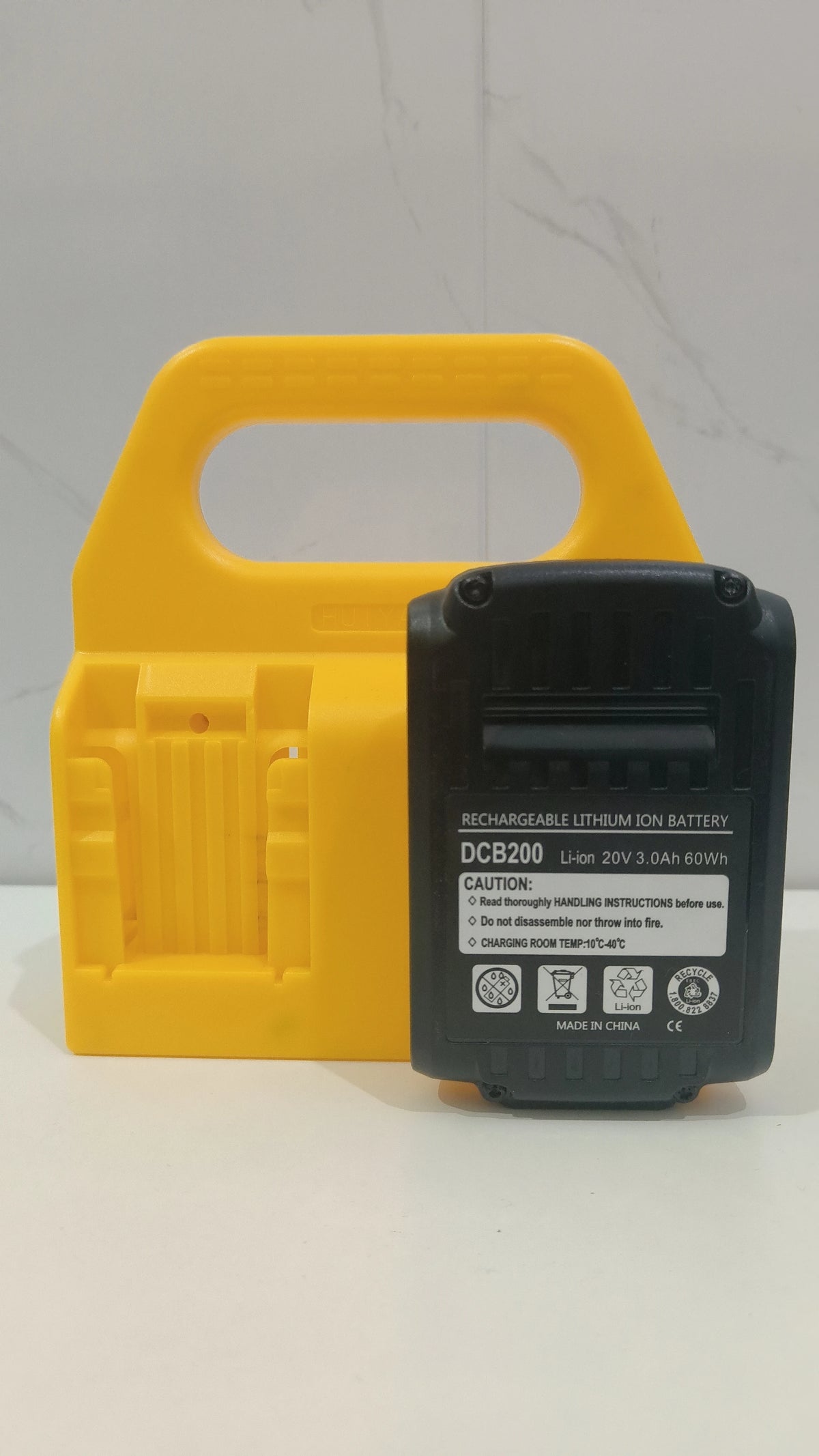 A yellow battery storage rack holding a black rechargeable lithium ion battery DCB200