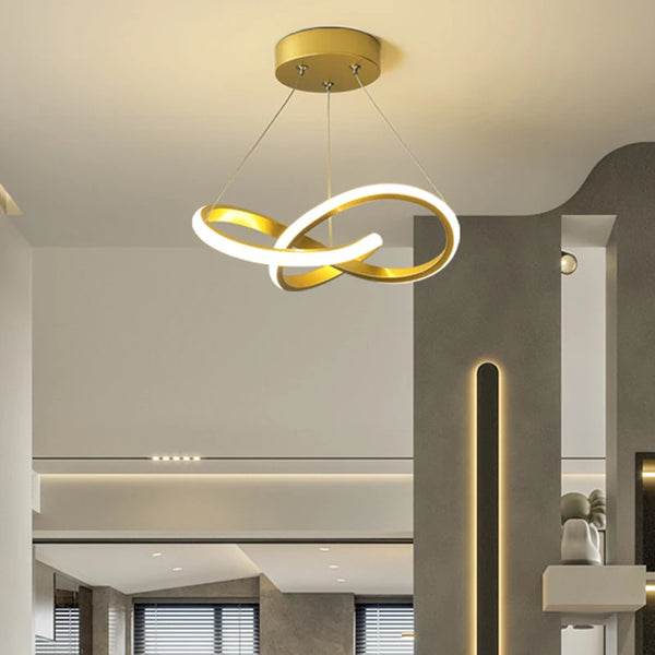 Modern gold LED ceiling pendant light with a curved, glowing design suspended from the ceiling.