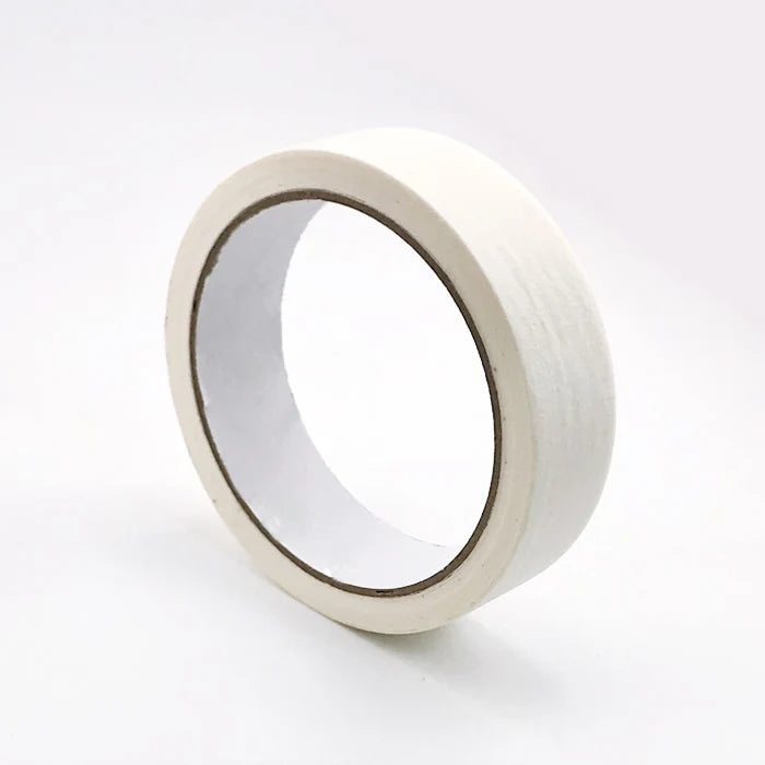 A roll of white painter's tape used for masking trim and grout.