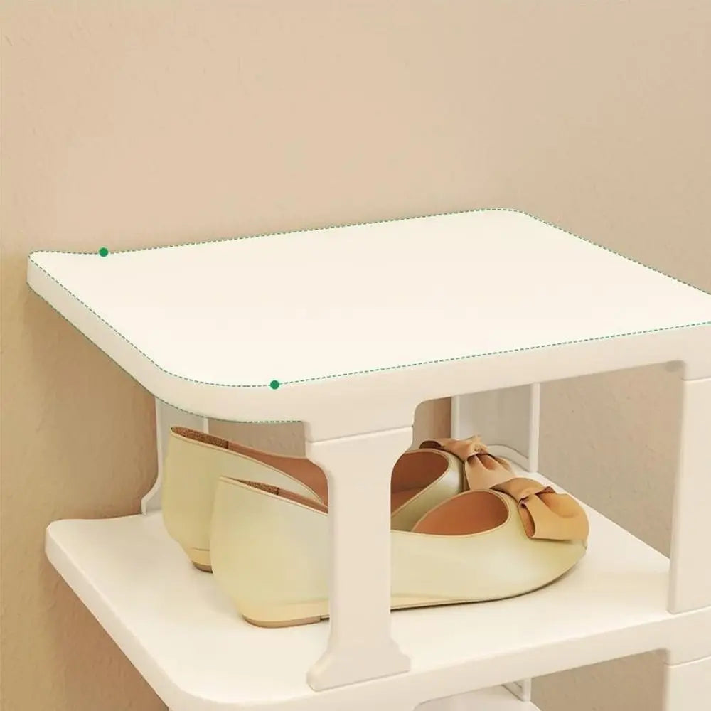 A white stackable vertical shoe rack organizer holding several pairs of tan and beige shoes.