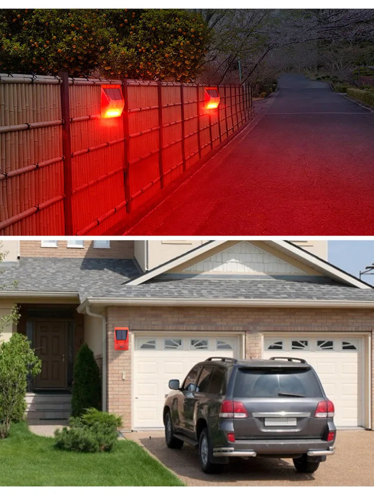A red solar motion sensor security alarm mounted on a fence, with a house and garage in the background.