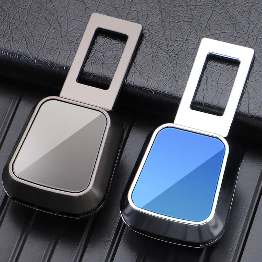 A silver and blue universal seatbelt clip extender with a rectangular design and a metal clasp.