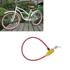 A bicycle with a pink frame and wheels is shown next to a red anti-theft cable lock.