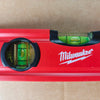 A red Milwaukee precision aluminum torpedo level set with a green liquid inside.