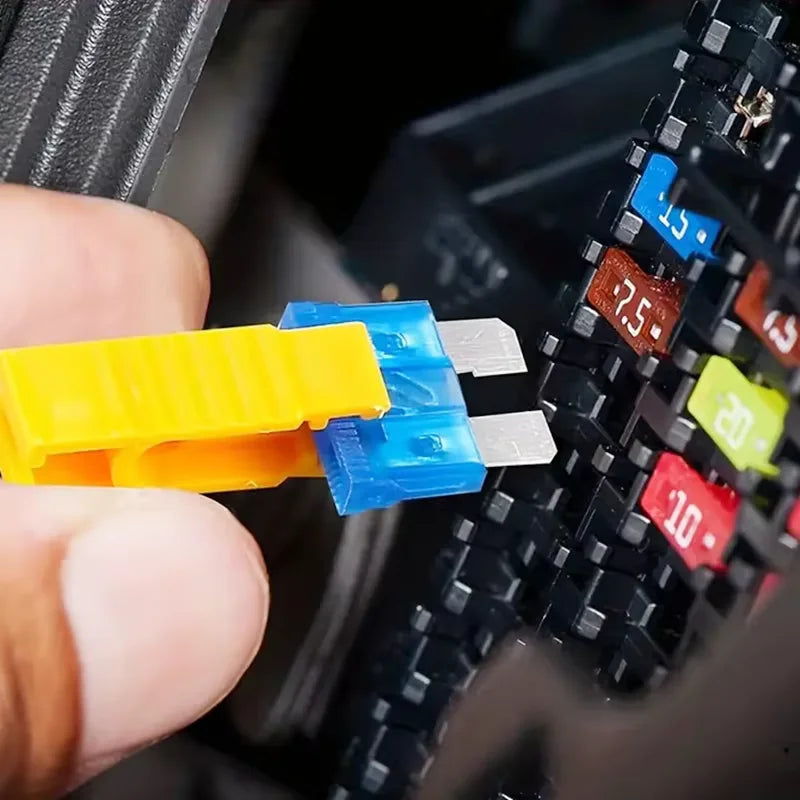 A hand is inserting a blue and silver fuse into a black plastic fuse holder for a precision car fuse combination kit.