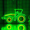 Neon-Schild in Form eines grünen Traktors mit gelben Akzenten vor dunkelgrünem Hintergrund