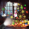 A festive scene showing a decorated Christmas tree illuminated by colorful LED projector lights and snowflakes.