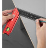 A hand is using a red precision stainless steel measuring ruler against a gray surface.