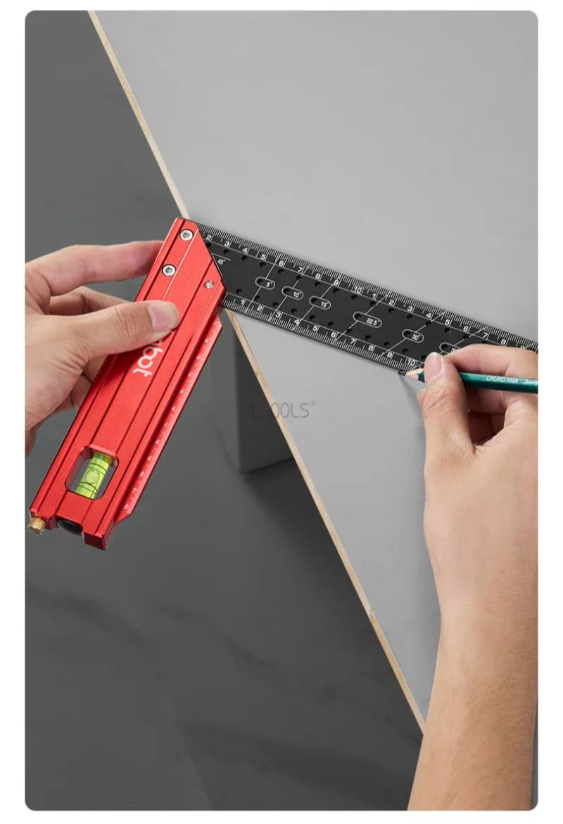A hand is using a red precision stainless steel measuring ruler against a gray surface.