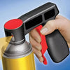 A hand holds a black spray paint handle with a red trigger, ready to be used on a yellow spray can.