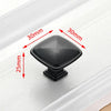 A black, square-shaped stainless steel kitchen door pull handle is shown with dimensions marked on a white surface.