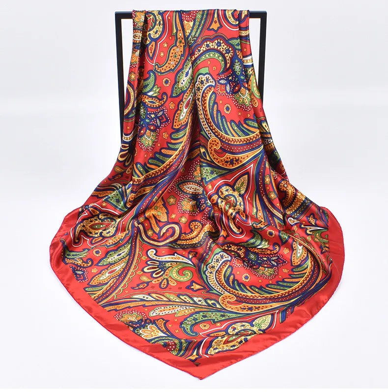 Foulard hijab en satin de soie rouge vif et orange or, avec des motifs paisley et floraux complexes.
