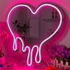 Leuchtendes neonrosa Herzschild beleuchtet einen Spiegel mit Topfpflanzen und Blumen.