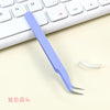 A purple precision crafting tweezers set lying on a white keyboard and light background.