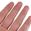 Several strands of gold and silver stainless steel beading chains are displayed on a hand.