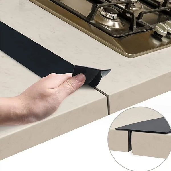 A hand is placing a black silicone sealing strip onto a gas stove burner.