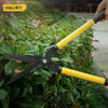 A pair of yellow and black pruning shears are shown cutting through green foliage.