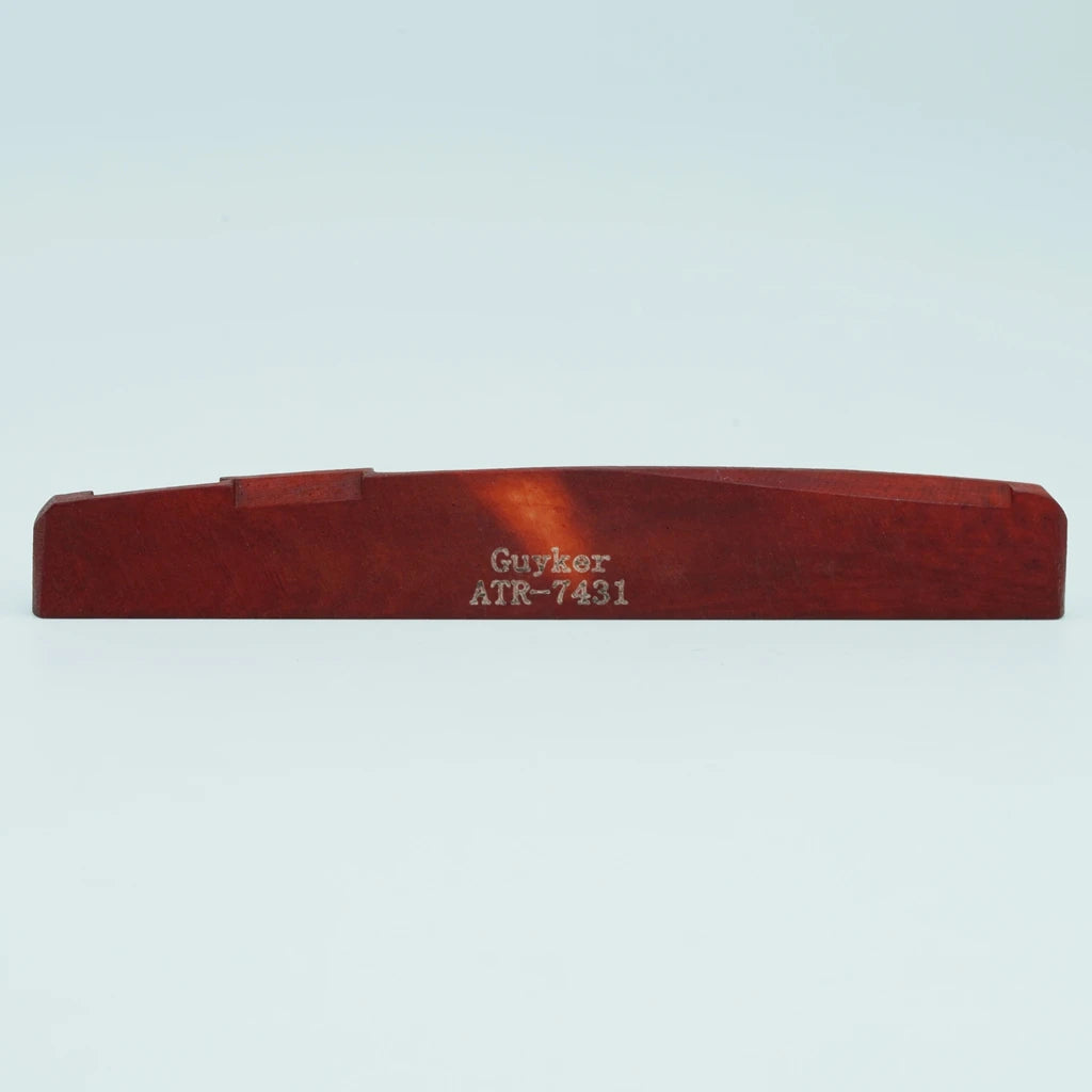 A wooden guitar bridge saddle with the name Guyker and model number ATR-7431 engraved on it.