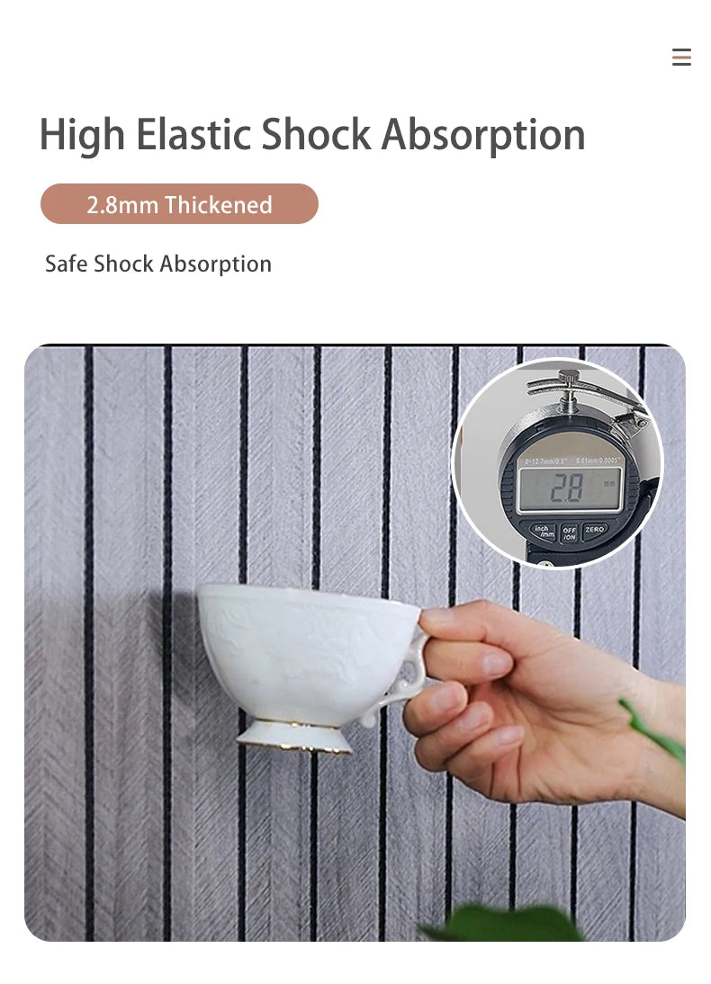 A hand holds a white ceramic cup against a striped surface, demonstrating high elastic shock absorption.