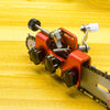 A precision chainsaw chain sharpening jig kit with orange and silver components resting on a wooden surface.