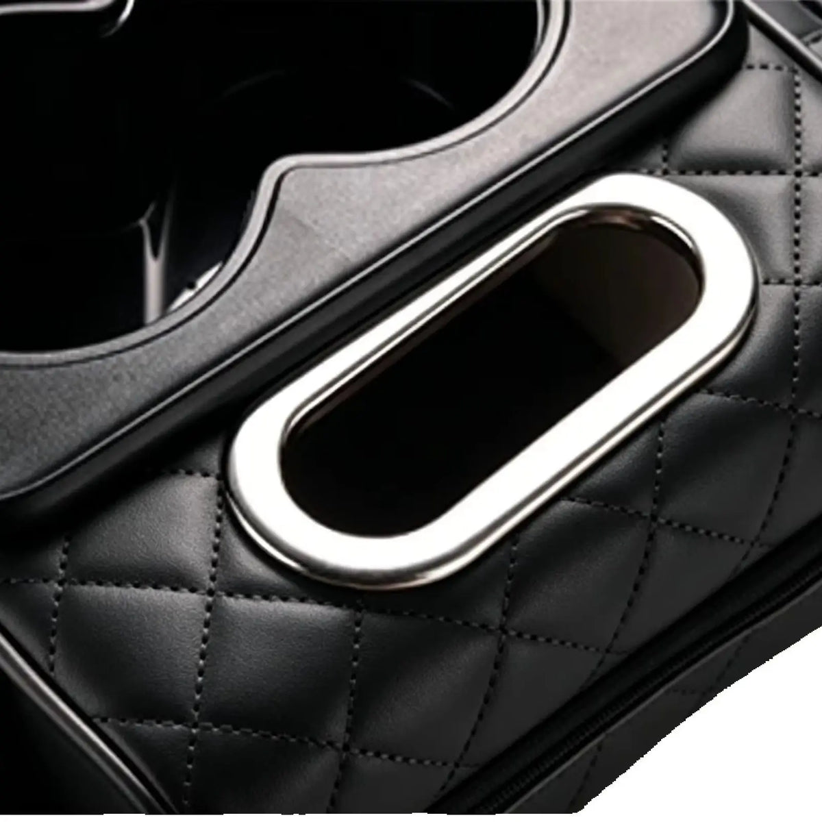 Close-up of a black quilted car armrest cushion with a silver cup holder.