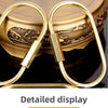 Gold-Messing-Schlüsselring-Karabinerclips auf dunker Oberfläche.