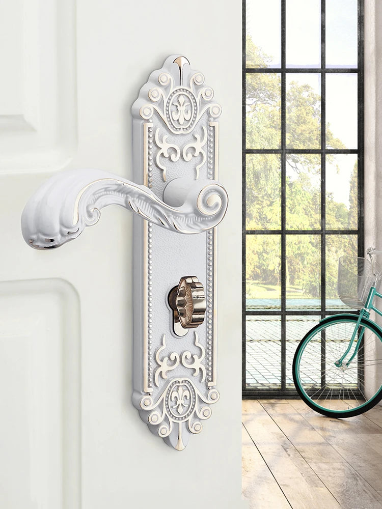 A decorative silver European style door lock with an ornate handle and keyhole mounted on a white wall.