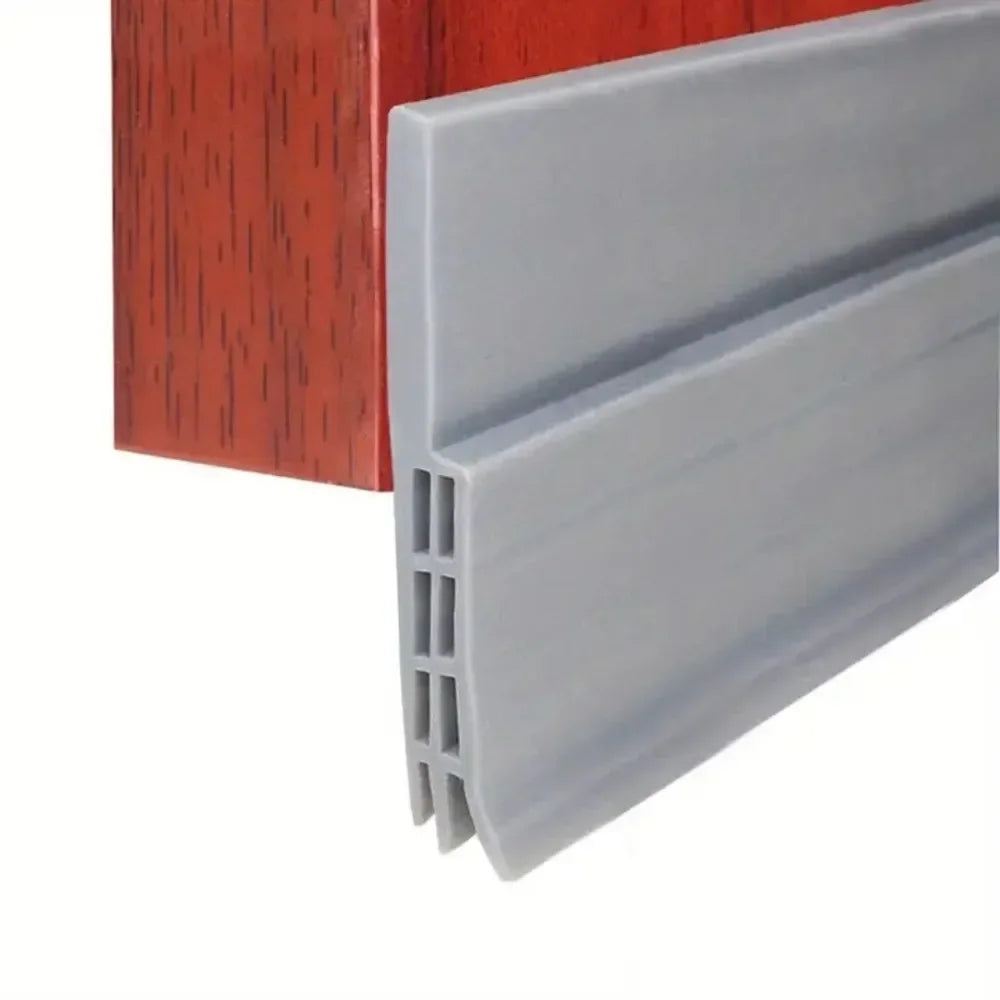 A gray door draft stopper seal strip is shown next to a reddish-brown wooden frame.