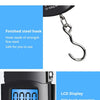 Close-up of a portable digital luggage scale showing 0.000 and a finished steel hook detail.