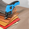 Ciseaux électriques portables bleu et noir posés sur une pile de sangles en cuir.