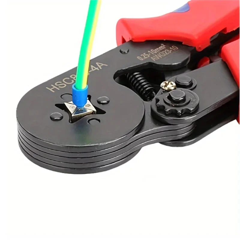 A close-up of a red crimping tool with a green and yellow wire being used to crimp an electrical terminal.