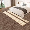 A bedroom with light wood grain peel and stick floor tiles casting shadows on the floor.