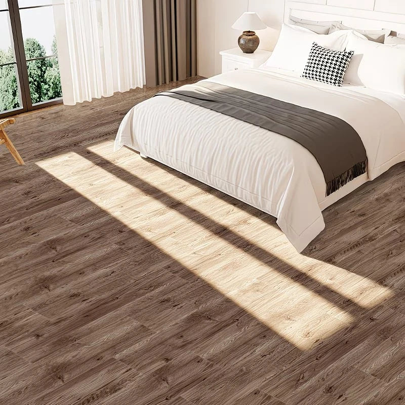 A bedroom with light wood grain peel and stick floor tiles casting shadows on the floor.